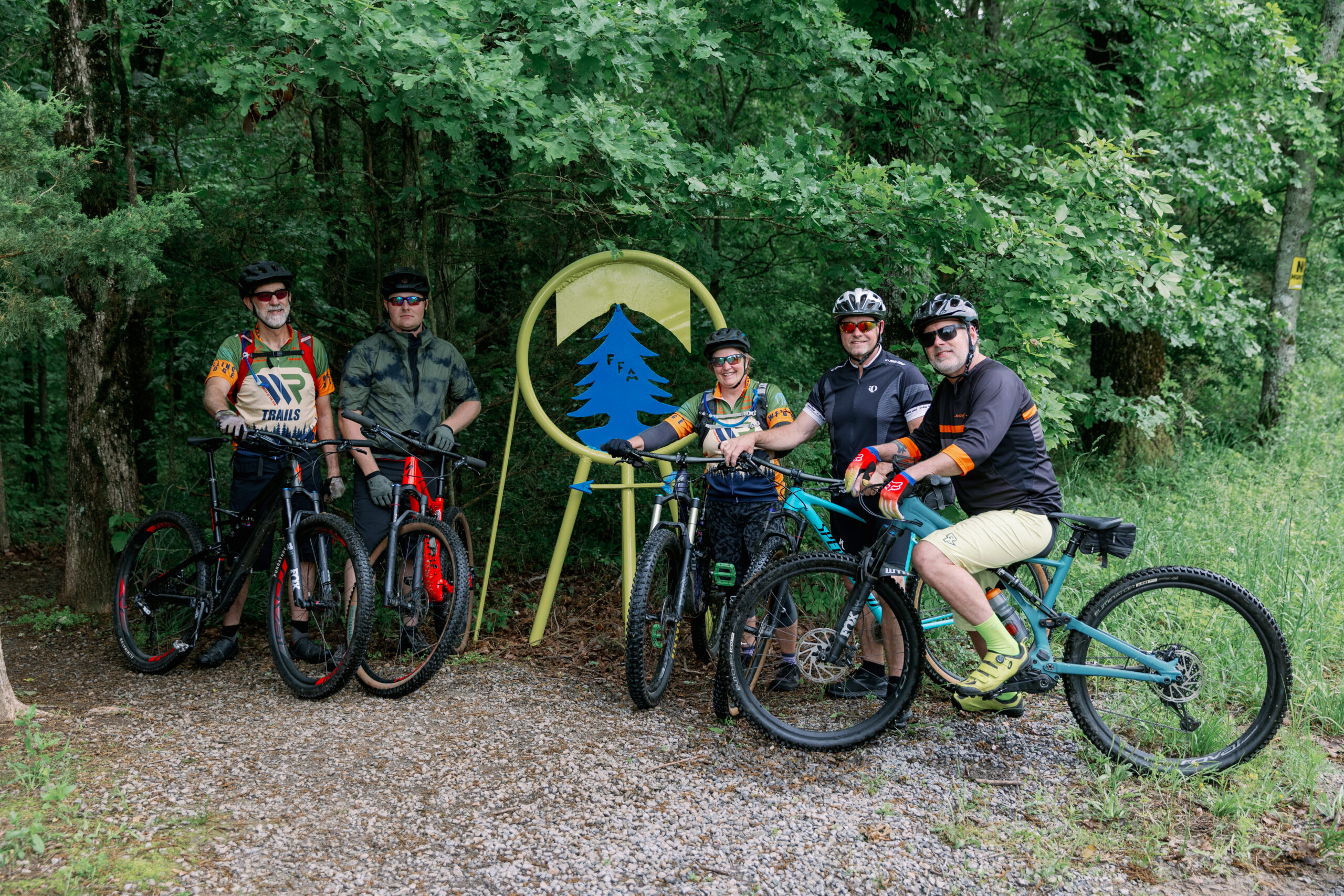 Five mountain bikers with their bikes beside a trail sign at Welling Ridge Trails
